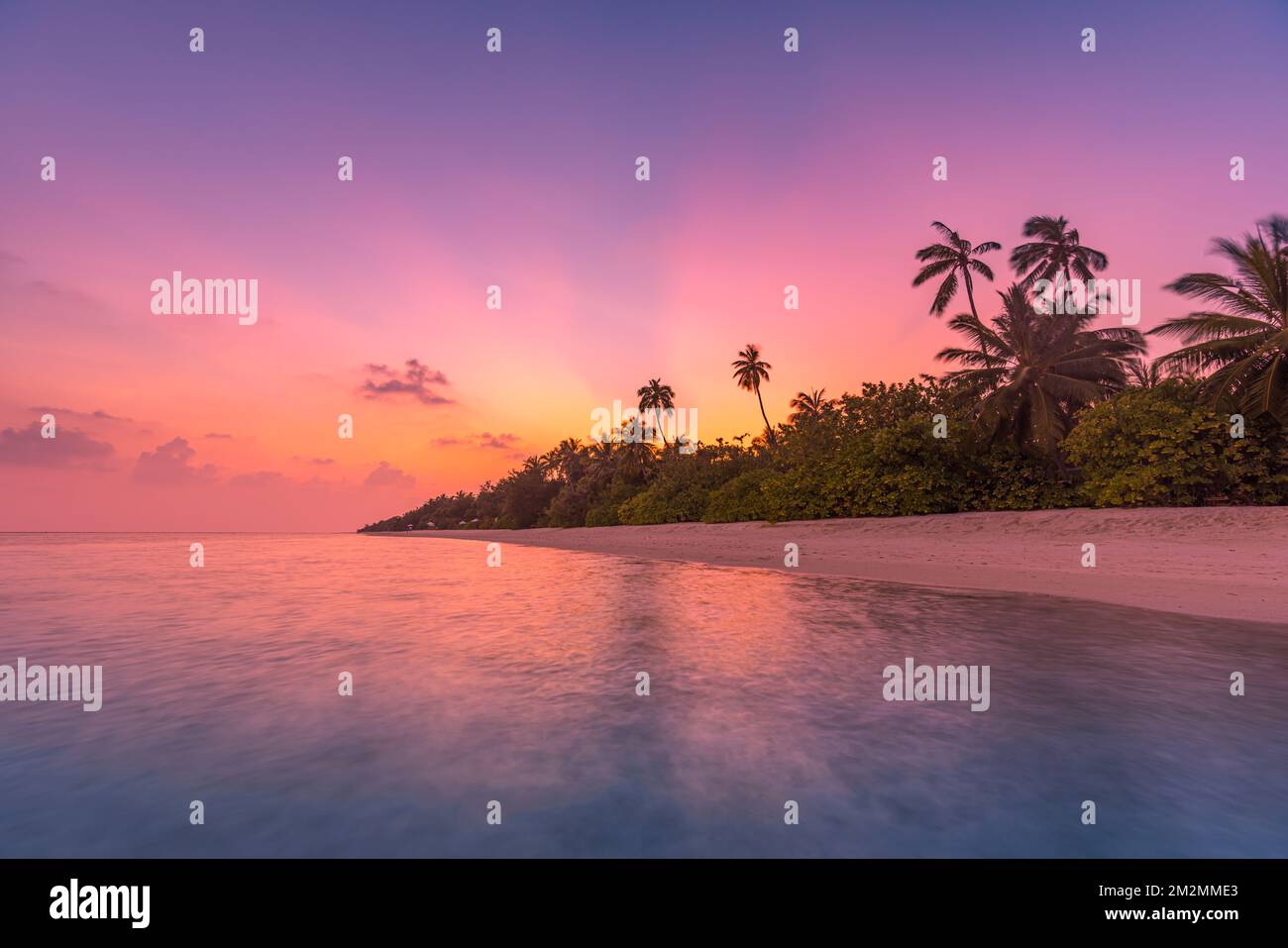 Fantastique vue tranquille de près des vagues d'eau de mer calmes avec lumière du soleil orangée au lever du soleil. Paysage tropical de plage d'île, côte exotique de rivage Banque D'Images