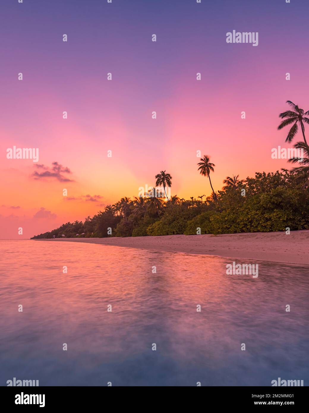 Fantastique vue tranquille de près des vagues d'eau de mer calmes avec lumière du soleil orangée au lever du soleil. Paysage tropical de plage d'île, côte exotique de rivage Banque D'Images