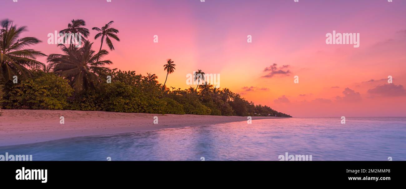 Fantastique vue tranquille de près des vagues d'eau de mer calmes avec lumière du soleil orangée au lever du soleil. Paysage tropical de plage d'île, côte exotique de rivage Banque D'Images