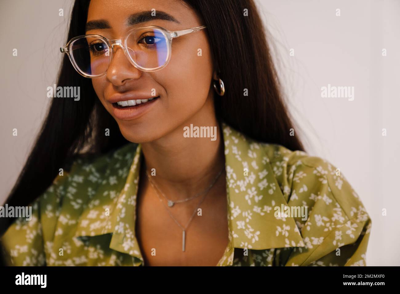 Portrait de jeune belle femme en lunettes et blouse verte regardant à l'écran Banque D'Images