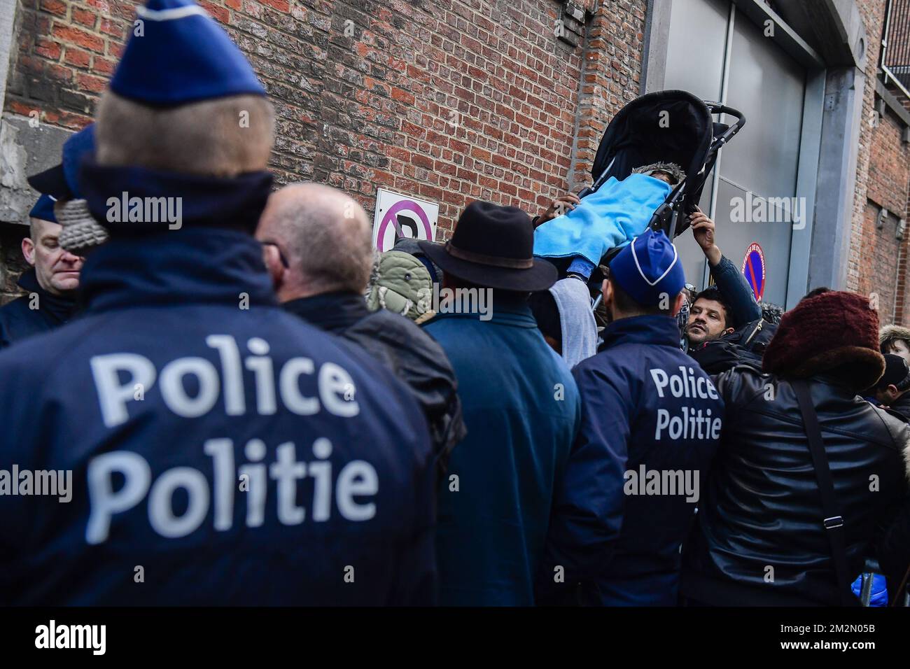 La police regarde les gens dans la foule soulever un buggy avec un enfant à l'intérieur, tandis que les gens font la queue dehors pour entrer à l'entrée arrière de la situation au nouveau centre d'enregistrement pour les demandeurs d'asile au petit Château - Klein Kasteeltje à Bruxelles, Lundi 10 décembre 2018. En raison d'un manque d'espace, les Services étrangers (DVZ Dienst Vreemdelingenzaken - ODE Office des Etrangers) l'enregistrement y a déménagé des bureaux près de Maximiliaanpark - Parc Maximilien. BELGA PHOTO LAURIE DIEFFEMBACQ Banque D'Images