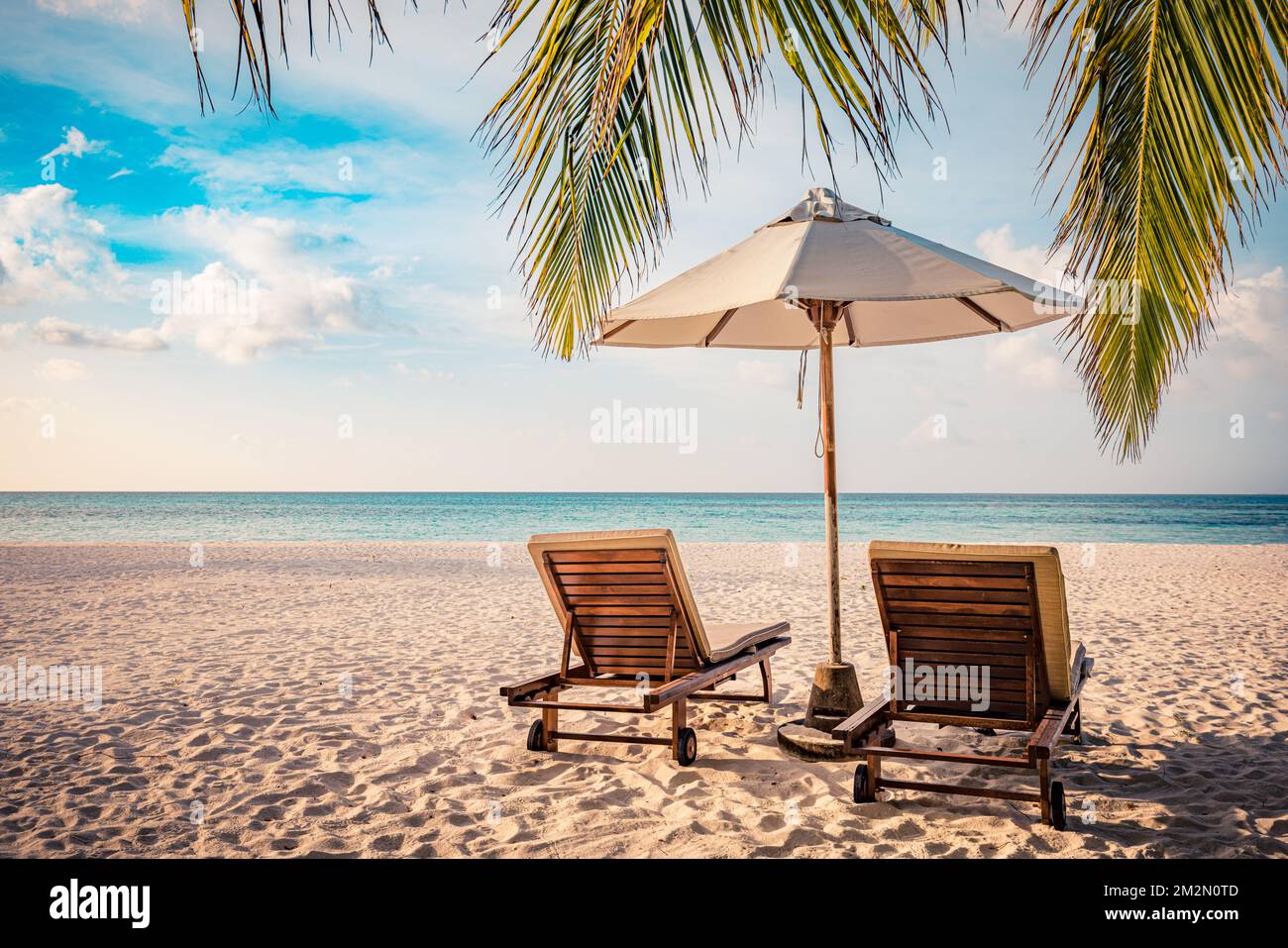 Couple de plage fantastique avec deux chaises longues sous un parasol et  des feuilles de palmier. Tropical nature paradis île rivage côte vue mer,  horizon Photo Stock - Alamy