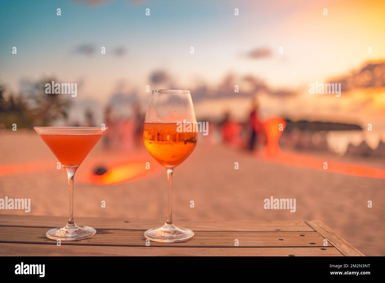 Deux cocktails avec plage floue et ciel de coucher de soleil coloré en arrière-plan. Luxe extérieur loisirs style de vie, détente et vibes romantiques Banque D'Images