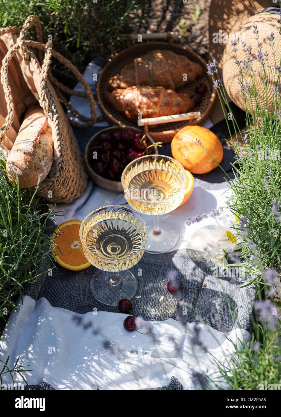 Pique-nique d'été sur un champ de lavande avec des verres de champagne et des fruits Banque D'Images