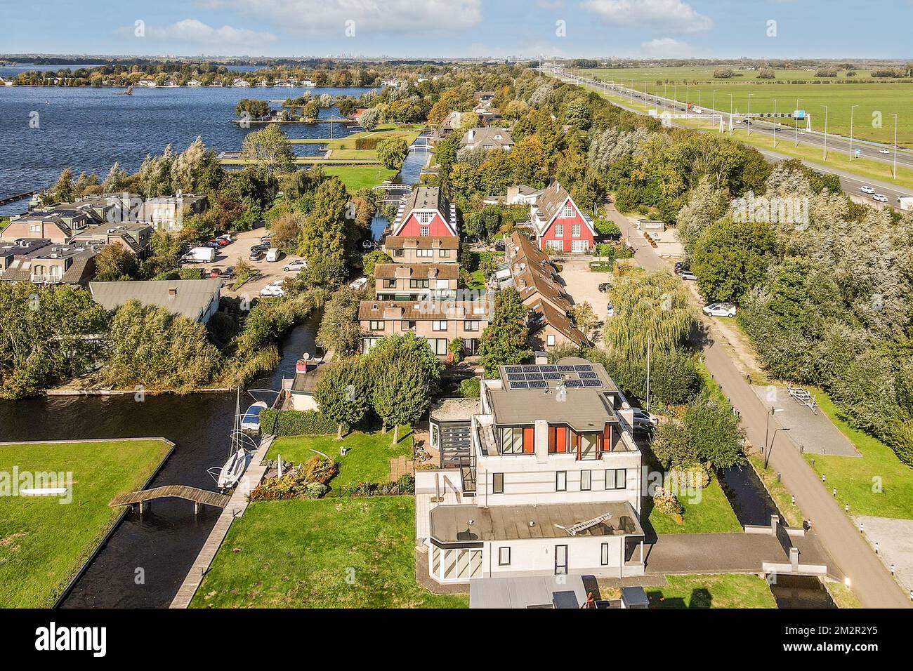 une vue aérienne de quelques maisons dans la région du pays avec un plan d'eau et des arbres des deux côtés Banque D'Images