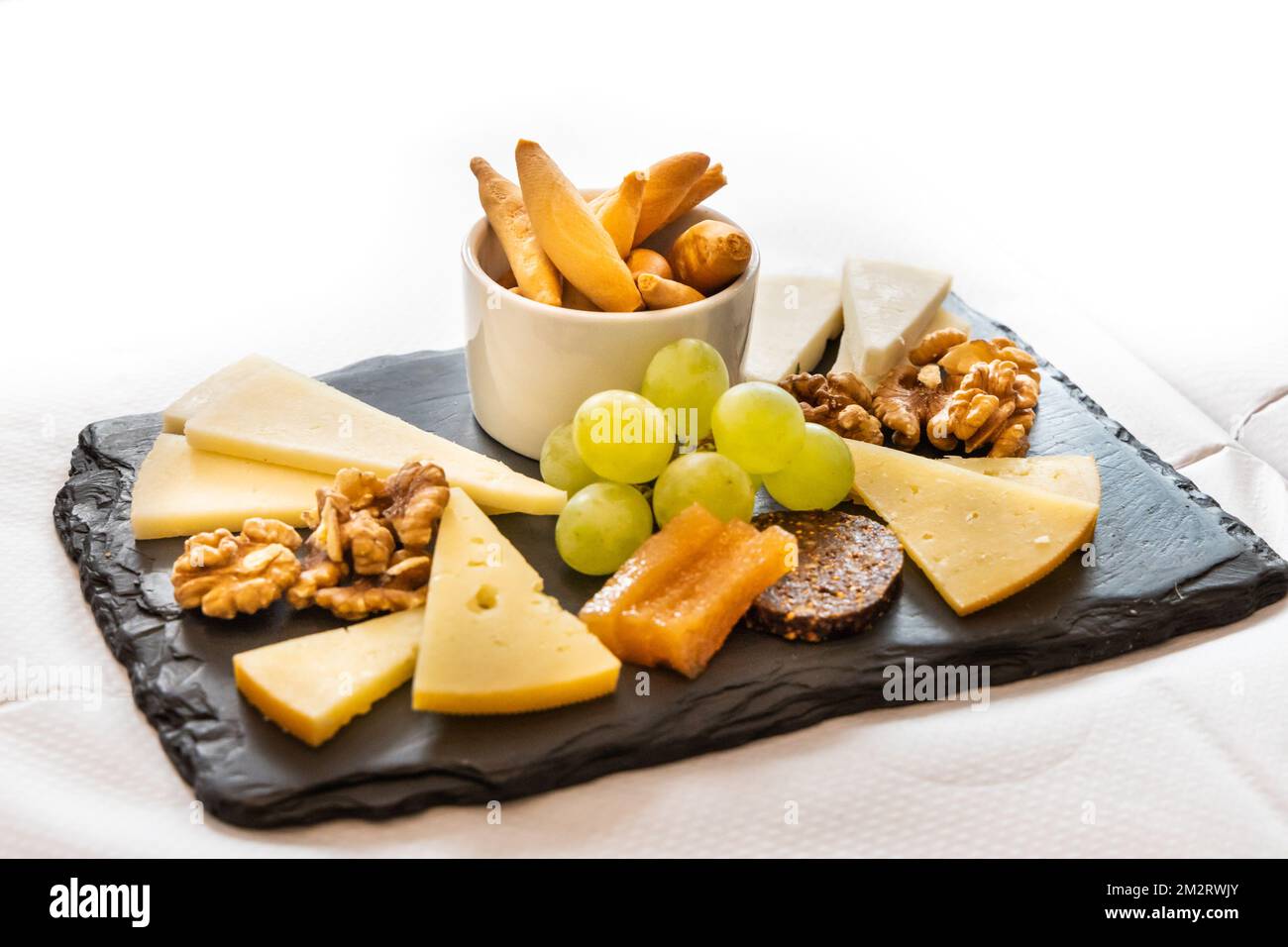 Plateau de fromages, de craquelins, de noix et de raisins servis sur des cheesboard Banque D'Images