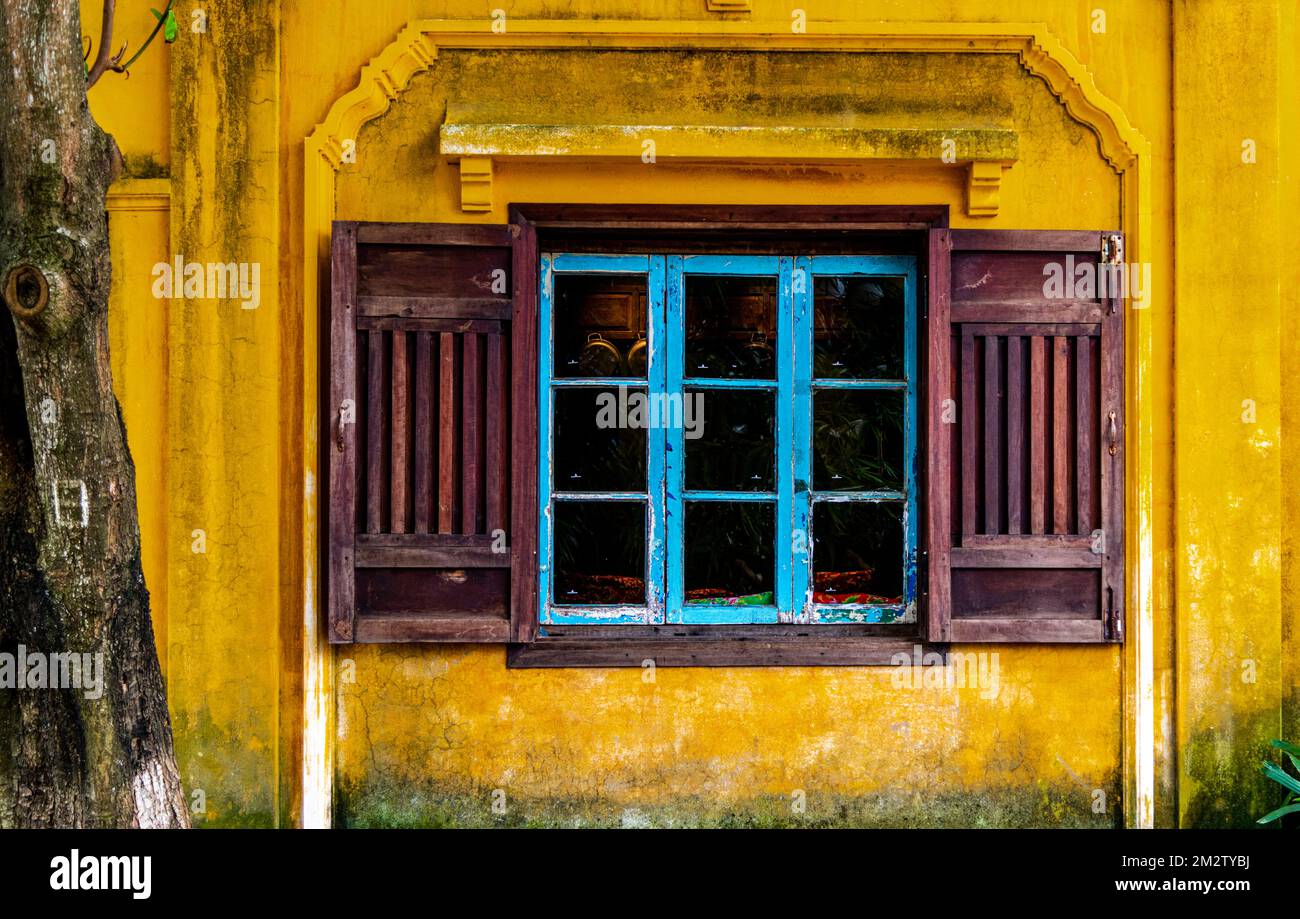 Une fenêtre dans la vieille ville de Hoi an qui est proche des nombreux touristes qui marchent dans la région. Banque D'Images