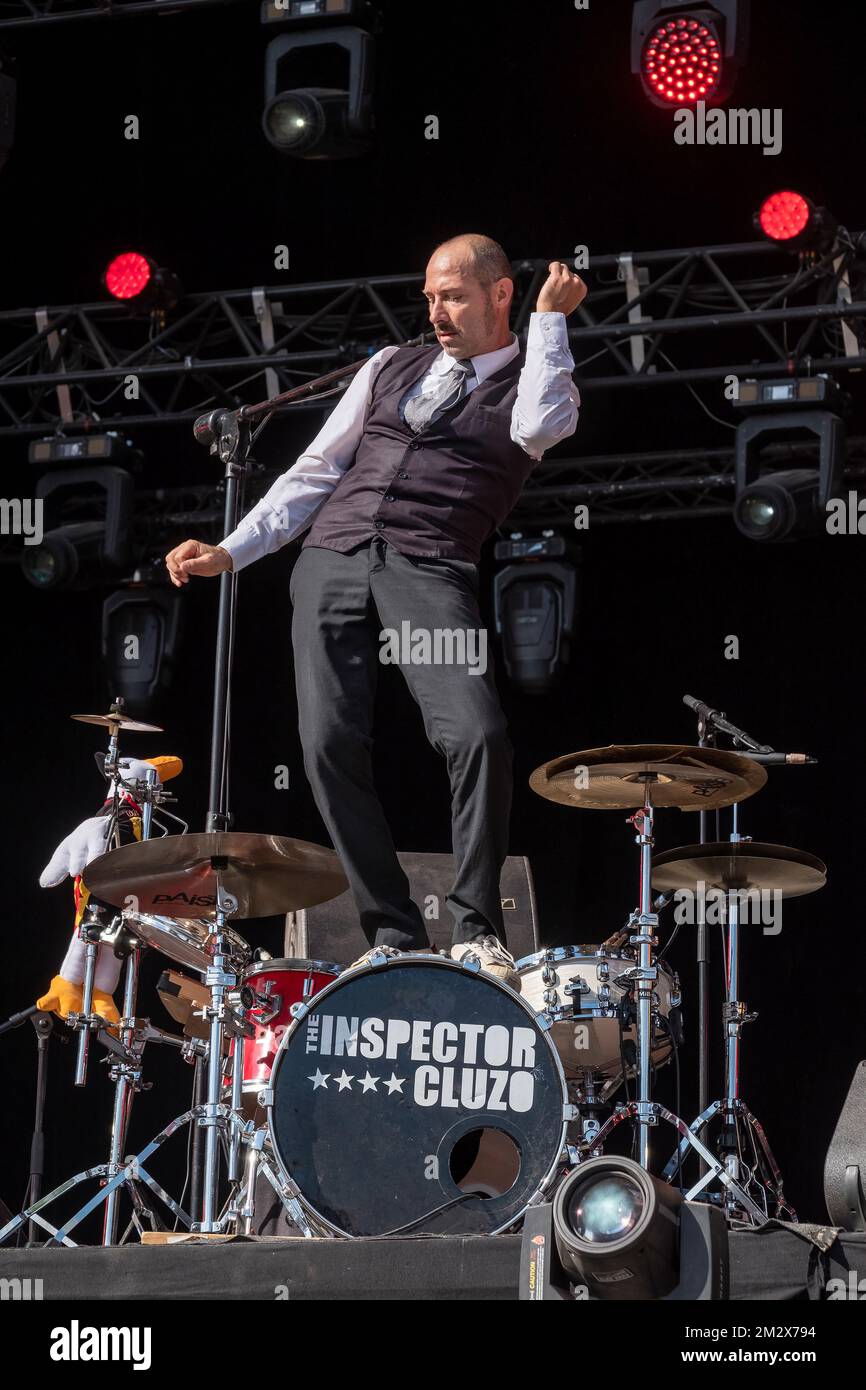 Le batteur du groupe de rock Inspector Cluzo debout sur son tambour de basse pour danser Banque D'Images