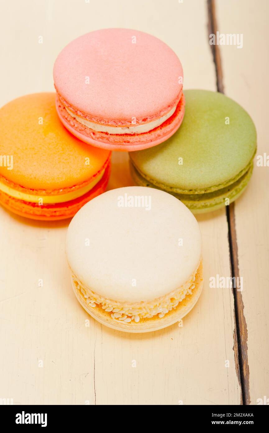Macarons français colorés sur une table en bois rustique blanc Banque D'Images