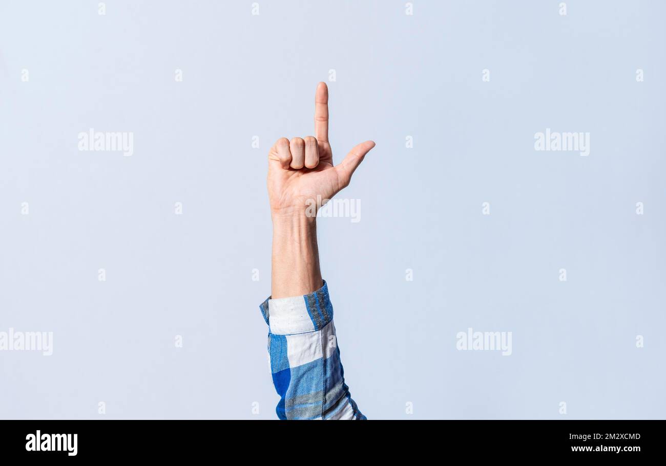 Gestuelle de la lettre L en langage des signes sur un fond isolé. Main de l'homme gestant la lettre L de l'alphabet isolé. Lettres du Banque D'Images