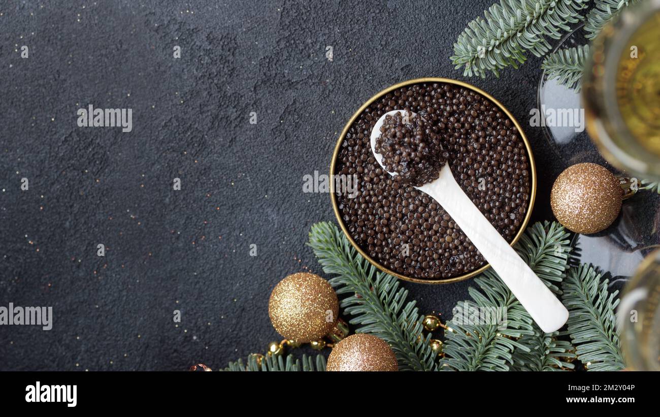 Caviar noir hors-d'œuvre étoiles sur une table noire décorée de noël bannière horizontale avec copyspace Banque D'Images