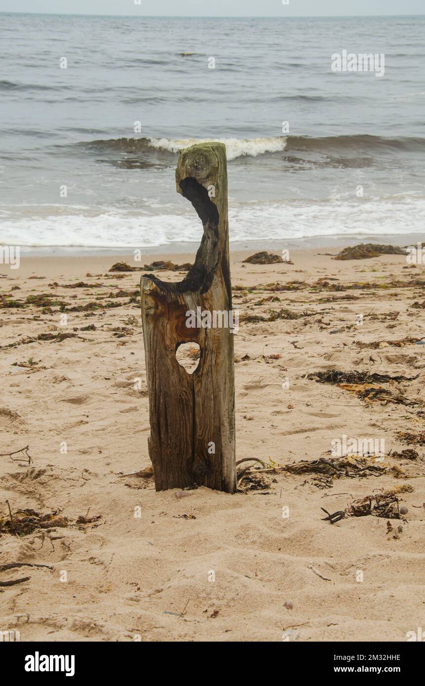 Cushendun County Down Northern Ireland, 08 septembre 2022 - un seul poste de clôture érodé et érodé sur la plage de Cushendun Banque D'Images