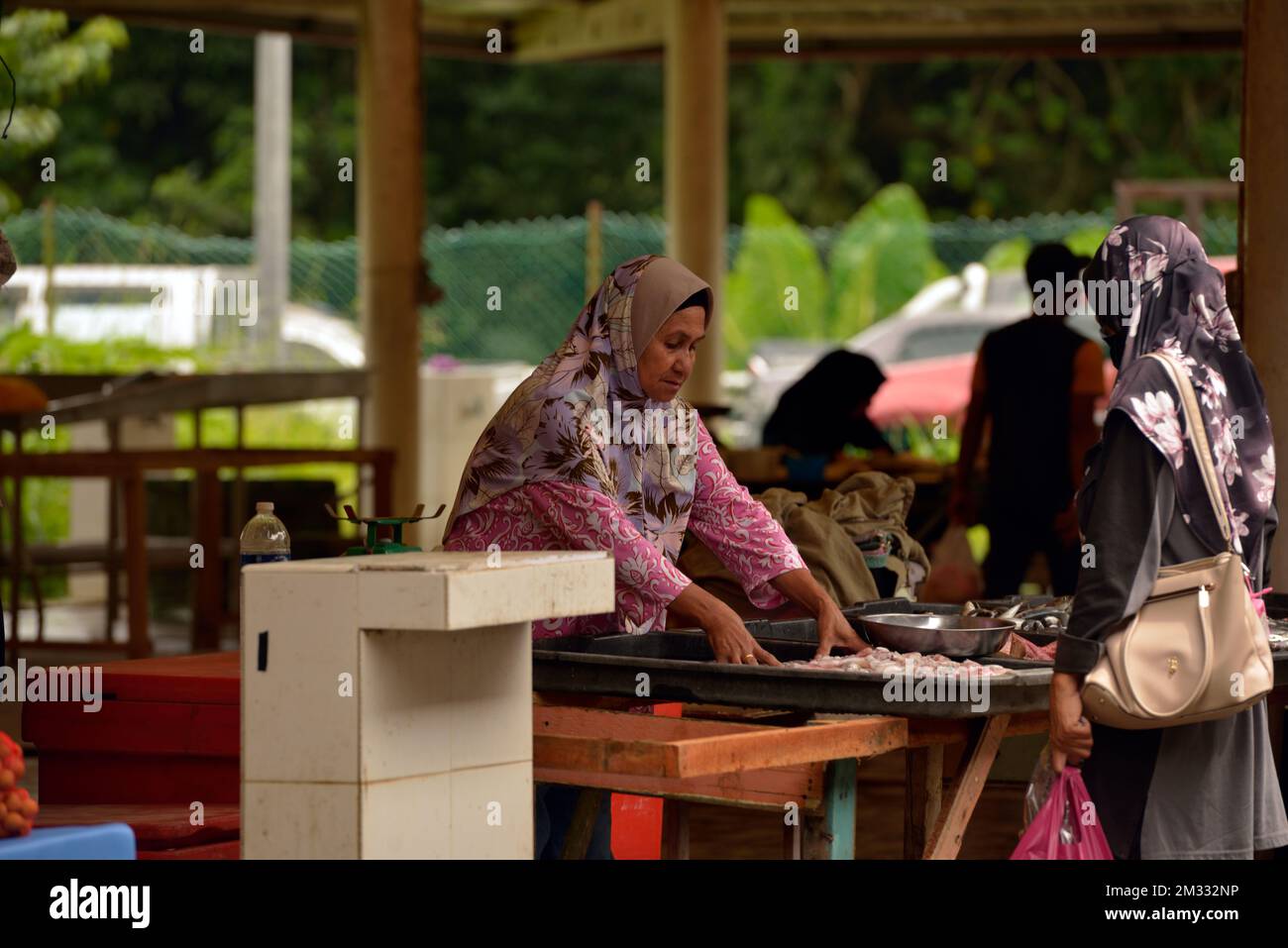 Une femme indigène Bajau vend du poisson et des fruits de mer au marché du dimanche (tamu) à Kota Belud, Sabah, Bornéo, Malaisie. Banque D'Images
