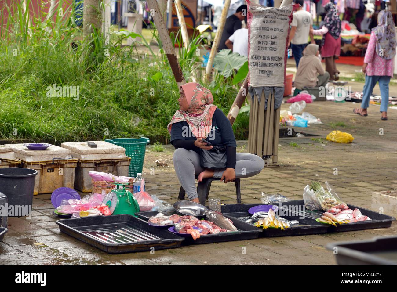 Une femme indigène Bajau vend du poisson et des fruits de mer au marché du dimanche (tamu) à Kota Belud, Sabah, Bornéo, Malaisie. Banque D'Images