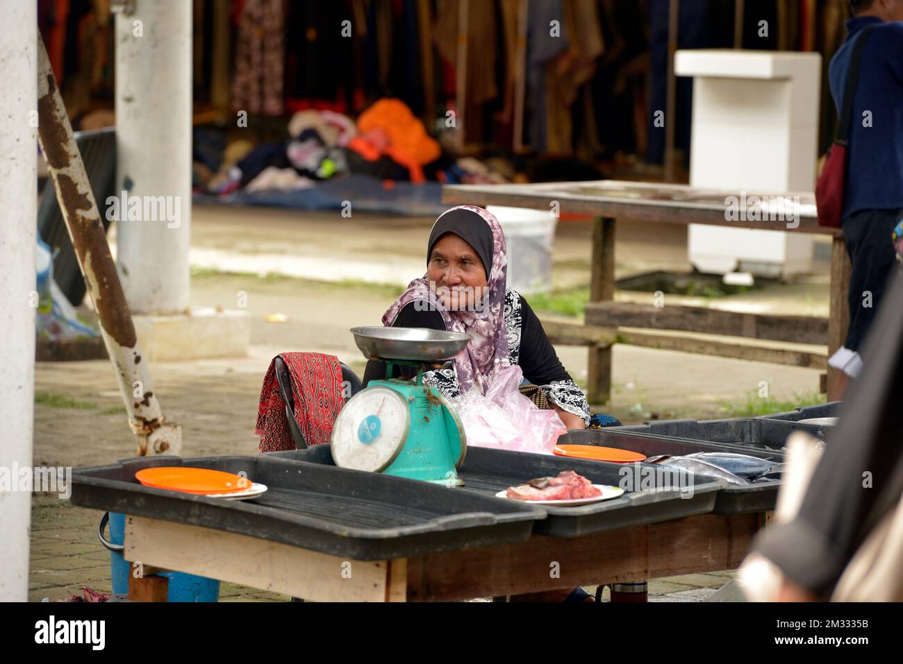 Une femme indigène Bajau vend du poisson au marché du dimanche (tamu) à Kota Belud, Sabah, Bornéo, Malaisie. Banque D'Images
