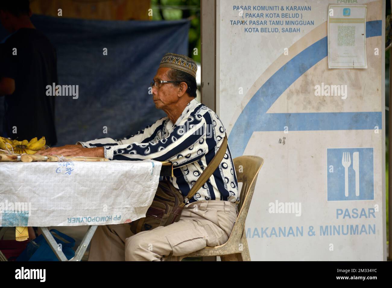 Un homme indigène Bajau vend de la nourriture au marché du dimanche (tamu) à Kota Belud, Sabah, Bornéo, Malaisie. Banque D'Images