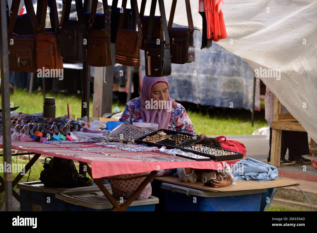 Une femme indigène Bajau vendant des bijoux et des sacs à main au marché du dimanche (tamu) à Kota Belud, Sabah, Bornéo, Malaisie. Banque D'Images