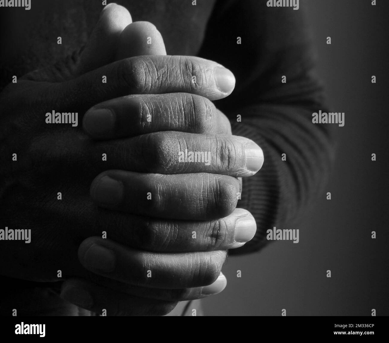 homme priant à dieu avec les mains avec l'arrière-plan avec les gens stock photo Banque D'Images