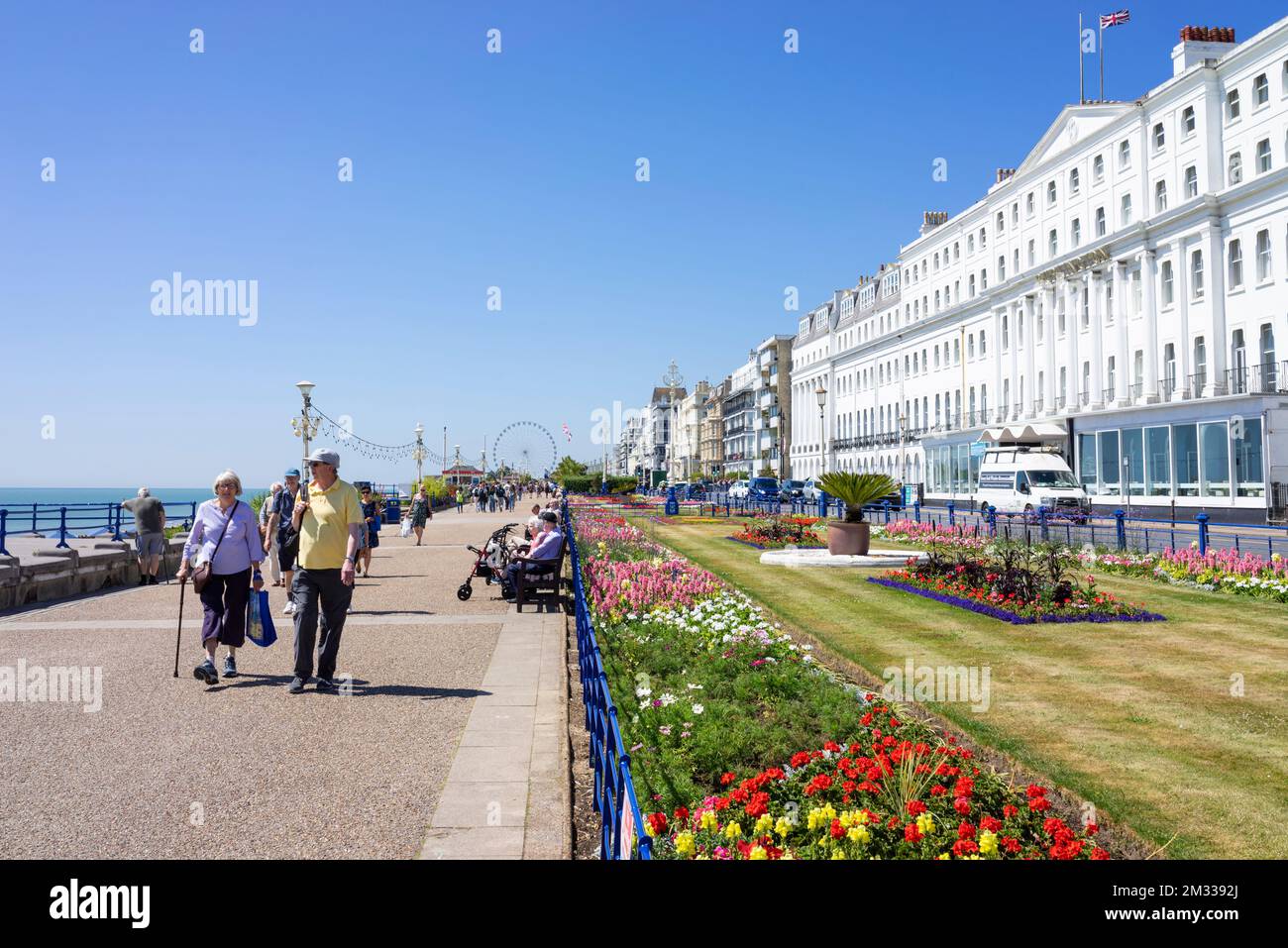 Eastbourne East Sussex Burlington Hotel sur la promenade du front de mer personnes marchant devant les jardins de tapis Eastbourne East Sussex Angleterre GB UK Europe Banque D'Images