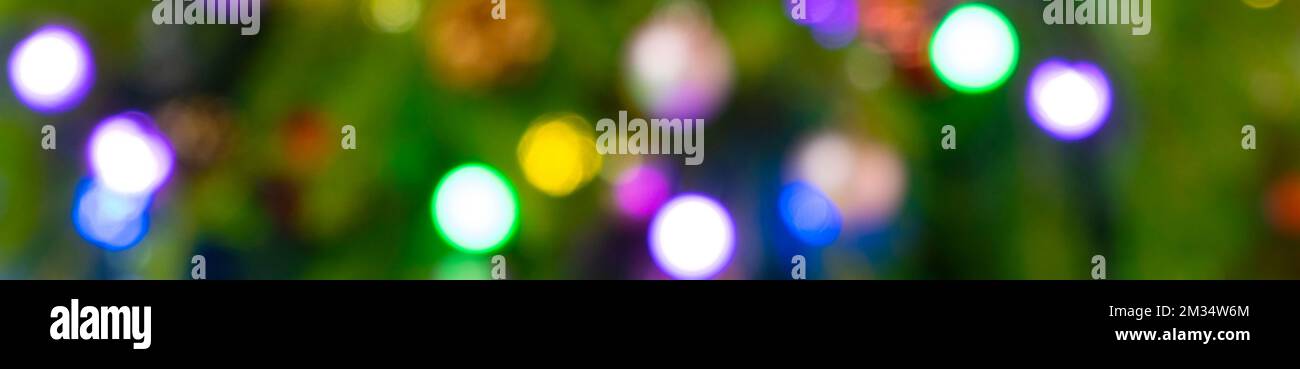 Image hors foyer d'un arbre de Noël décoré avec des ornements et des lumières colorés. Banque D'Images