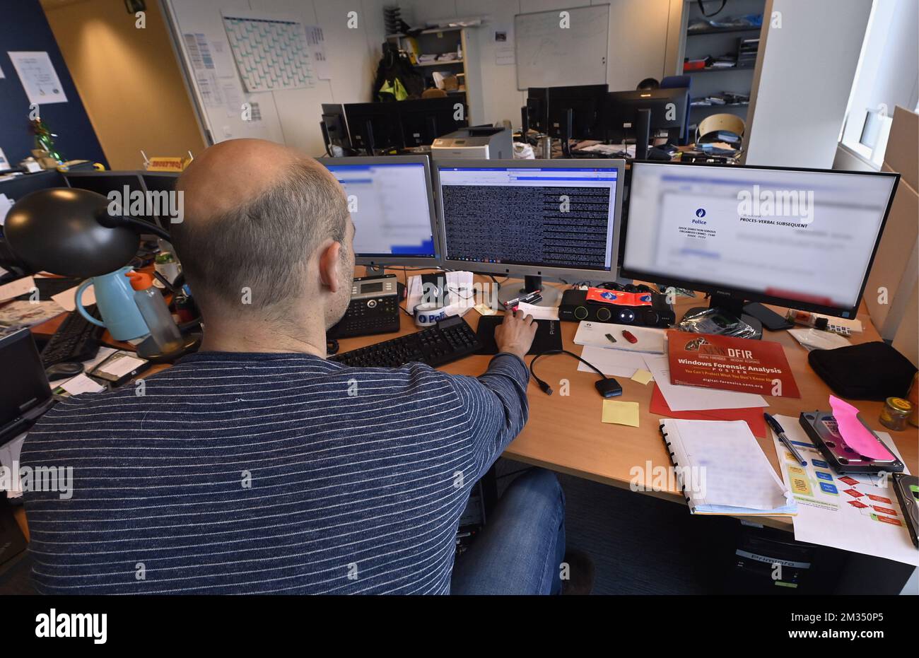 Un officier photographié à ce bureau dans les bureaux de l'unité fédérale de la criminalité informatique (FCCU) à Bruxelles, le jeudi 06 mai 2021. Plus tôt cette semaine, une cyberattaque importante a saboté plusieurs services informatiques d'organismes gouvernementaux, d'universités et d'écoles secondaires. BELGA PHOTO ERIC LALMAND Banque D'Images