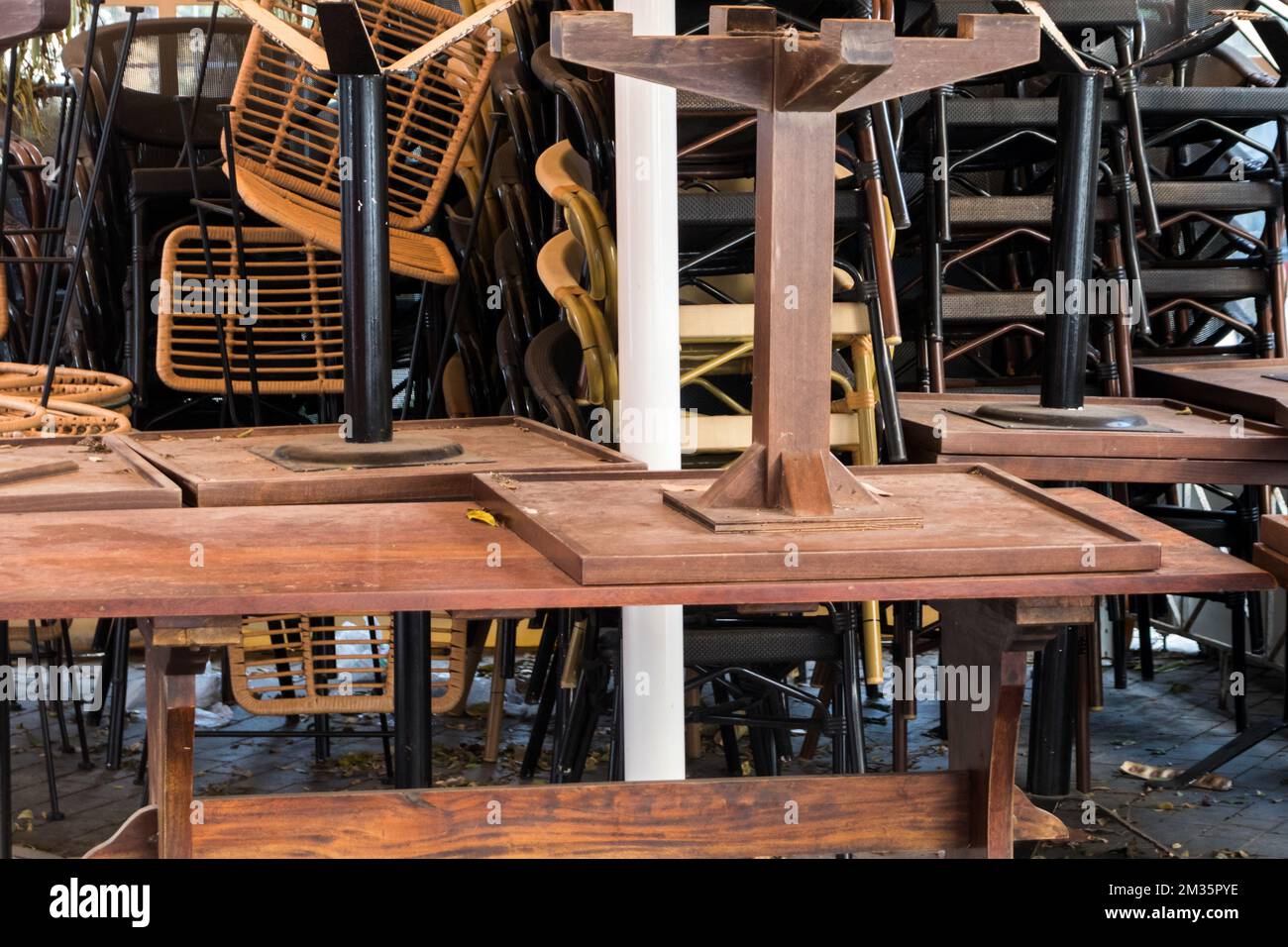 Sièges de table empilés à l'extérieur d'un magasin fermé. Banque D'Images