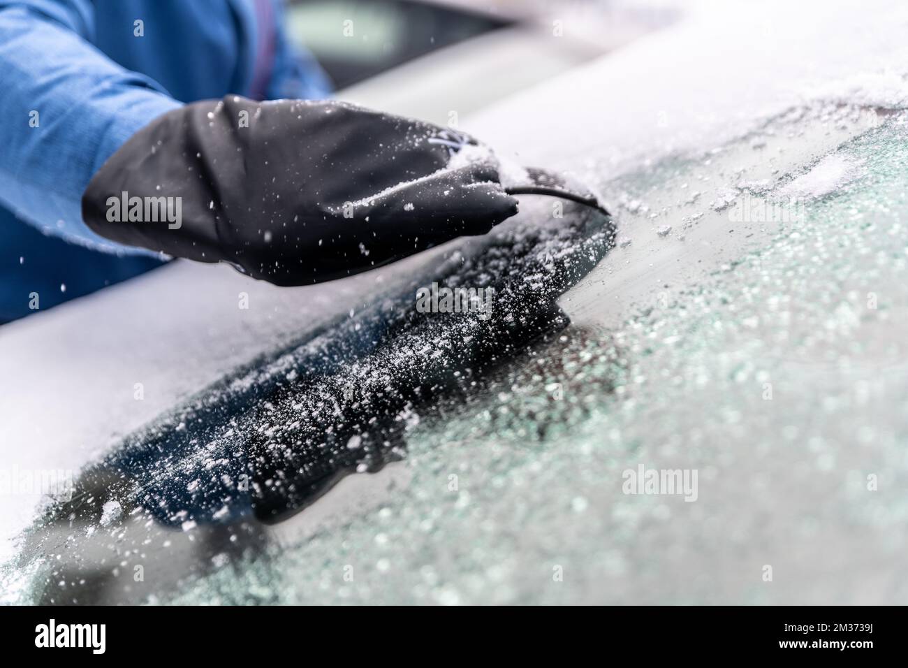 l'homme utilise des racloirs à glace pour dégeler le pare-brise de la  voiture Photo Stock - Alamy