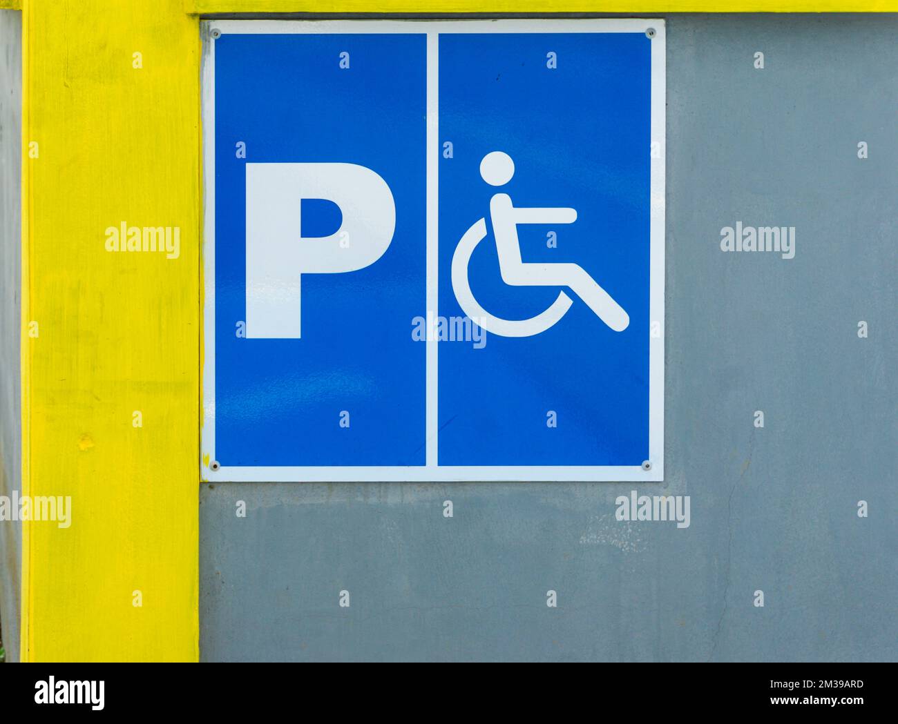 Panneau de stationnement pour personnes handicapées peint sur le mur en béton d'une zone publique Banque D'Images