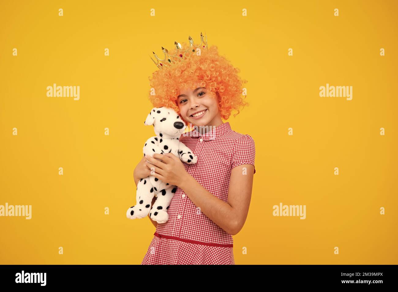 Fête des filles, drôle d'enfant dans la perruque de clown fantaisie dans la couronne. Enfant queen porter le diadem tiara. Joli petit portrait de princesse. Banque D'Images