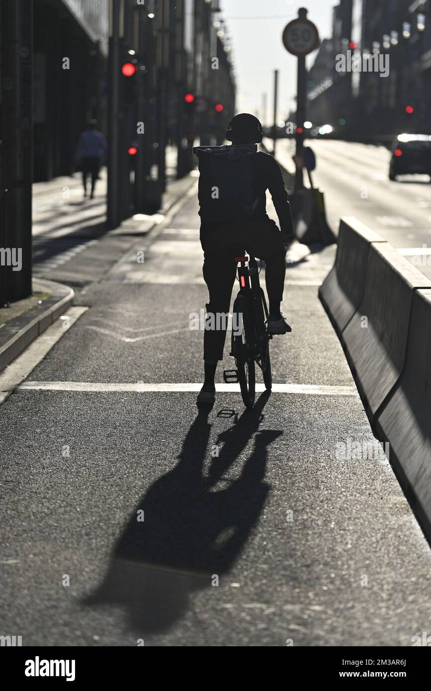 L'illustration montre un cycliste qui attend au feu rouge, dans la rue de la Loi - Wetstraat, à Bruxelles, le lundi 27 juin 2022. La rue de la Loi - Wetstraat (hollandaise), qui signifie « rue du droit », est une rue importante qui traverse le centre et l'est de Bruxelles, en Belgique, célèbre en raison de la présence de plusieurs bâtiments gouvernementaux belges et européens remarquables. BELGA PHOTO ERIC LALMAND Banque D'Images