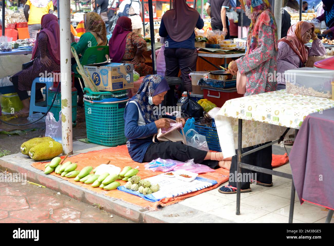 Une femme indigène Bajau vend de la nourriture au marché du dimanche à Kota Belud, Sabah, Bornéo, Malaisie. Banque D'Images