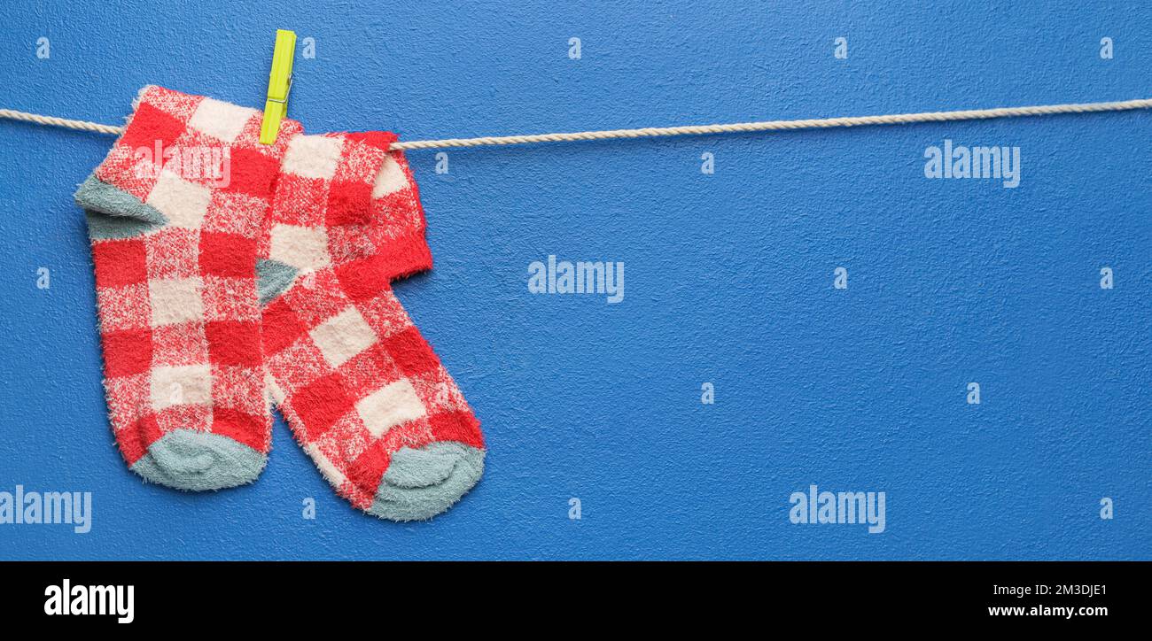 Corde avec chaussettes chaudes sur fond bleu Banque D'Images