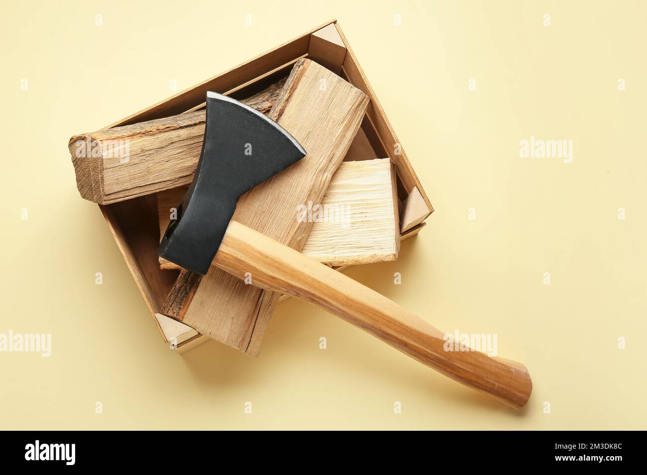 Hache avec bois de chauffage sur fond jaune Banque D'Images