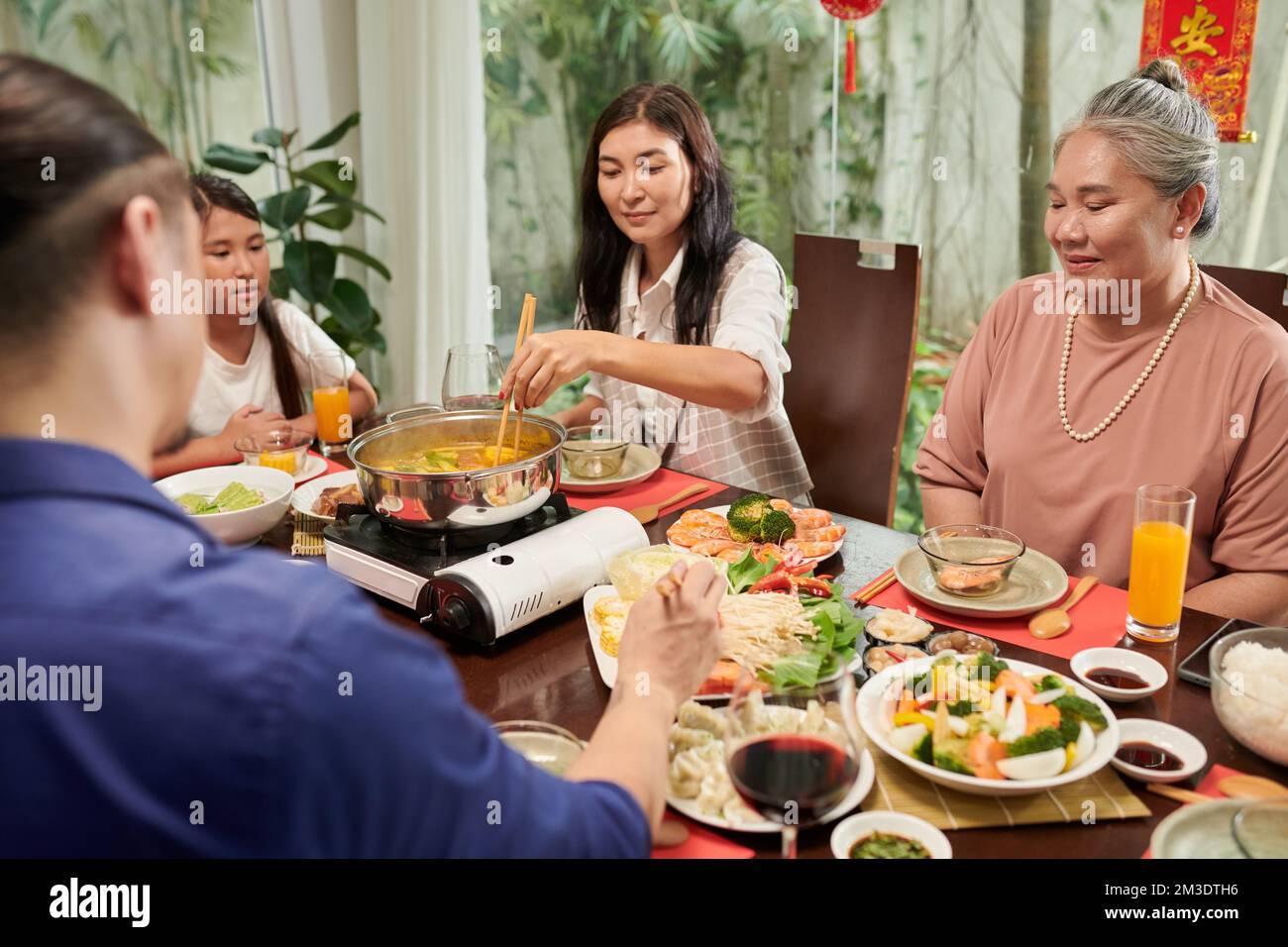 Grande famille qui apprécie la fête du nouvel an chinois et qui mange de la cuisine traditionnelle à la maison Banque D'Images
