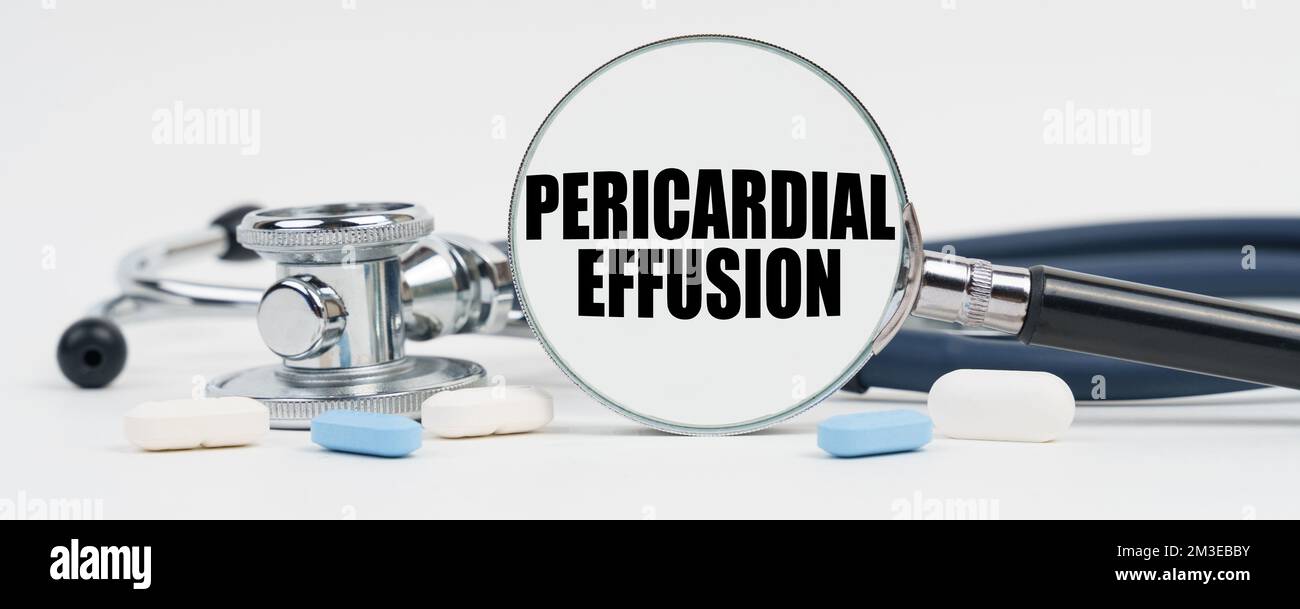 Médecine et concept de santé. Sur une surface blanche sont des pilules, un stéthoscope et une loupe à l'intérieur qui est écrit - épanchement péricardique Banque D'Images