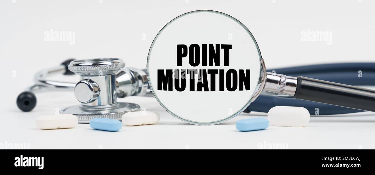 Médecine et concept de santé. Sur une surface blanche sont des pilules, un stéthoscope et une loupe à l'intérieur qui est écrit - mutation de point Banque D'Images