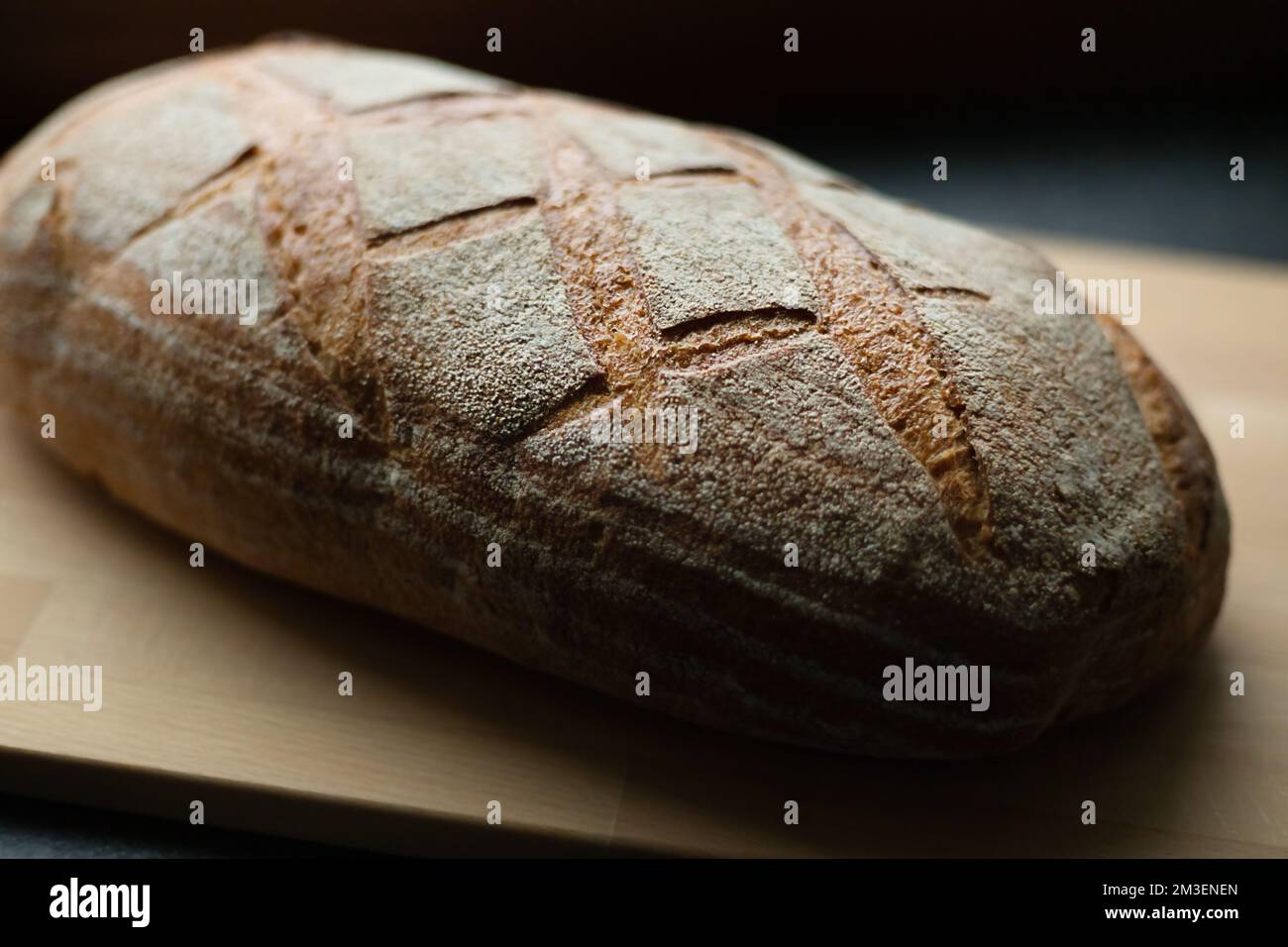 pain fraîchement cuit sur une table de cuisine gris foncé et une planche en bois, gros plan, vue en angle Banque D'Images