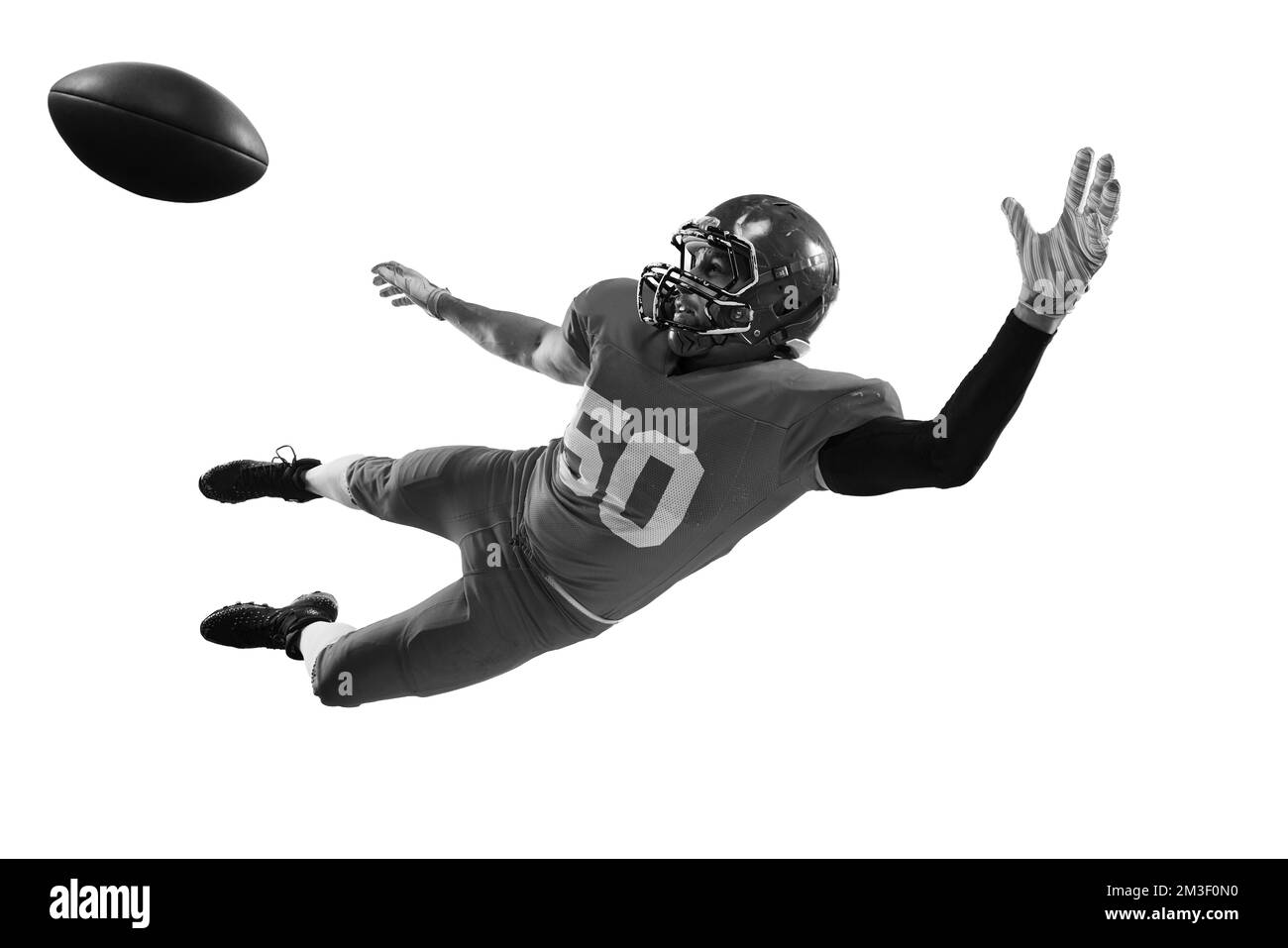 Portrait monochrome d'un joueur de football américain professionnel en uniforme sportif et casque de protection en mouvement isolé sur fond blanc. Banque D'Images