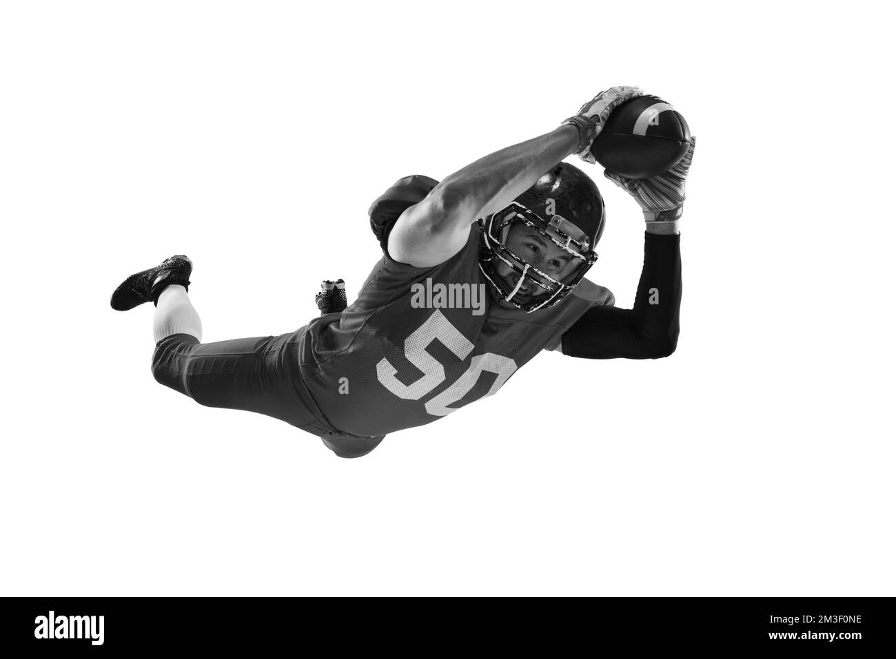 Portrait monochrome d'un joueur de football américain professionnel en uniforme sportif et casque de protection en mouvement isolé sur fond blanc. Banque D'Images