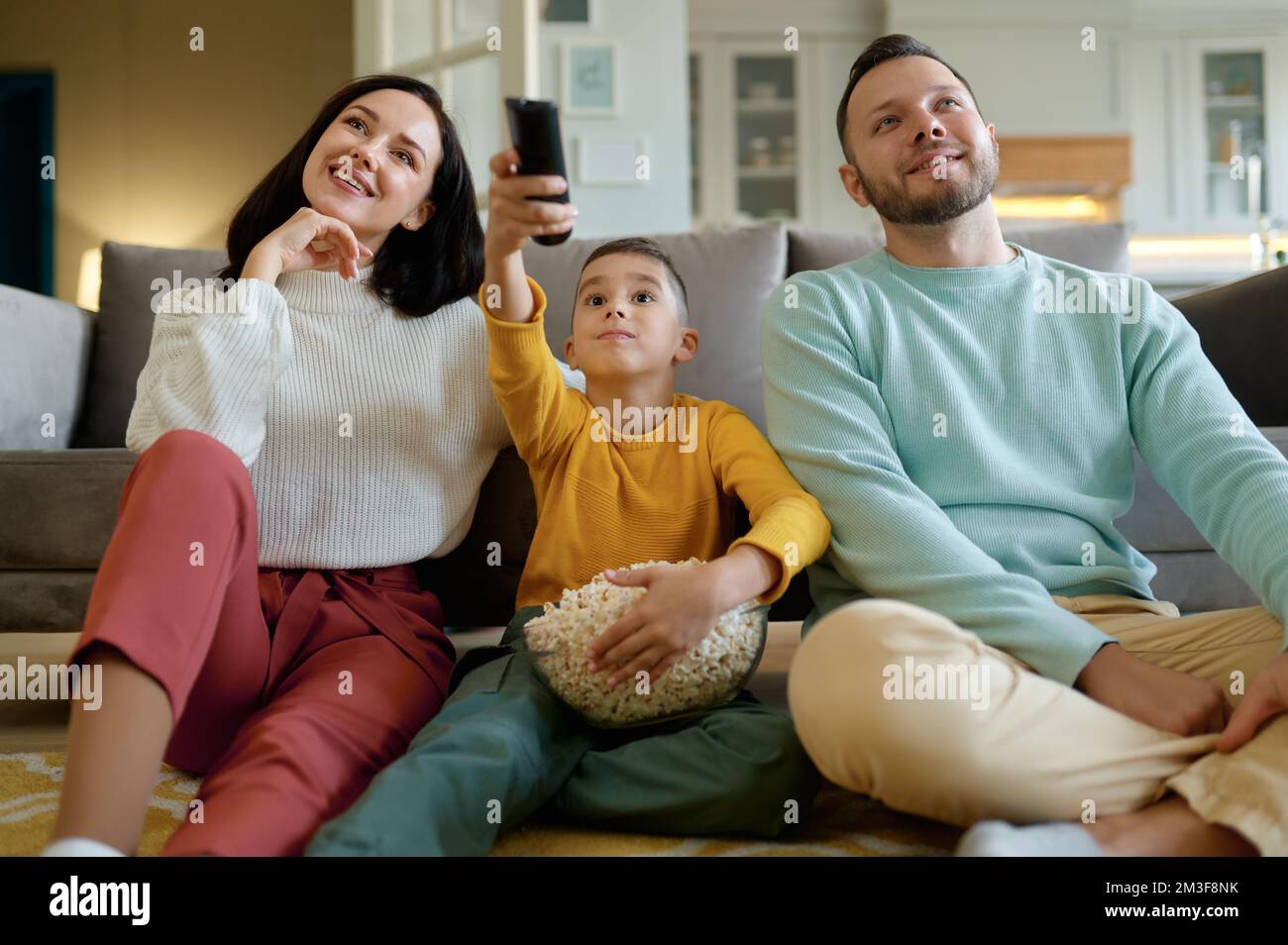 Des parents étonnés et des enfants curieux regardant un programme tv à la maison Banque D'Images