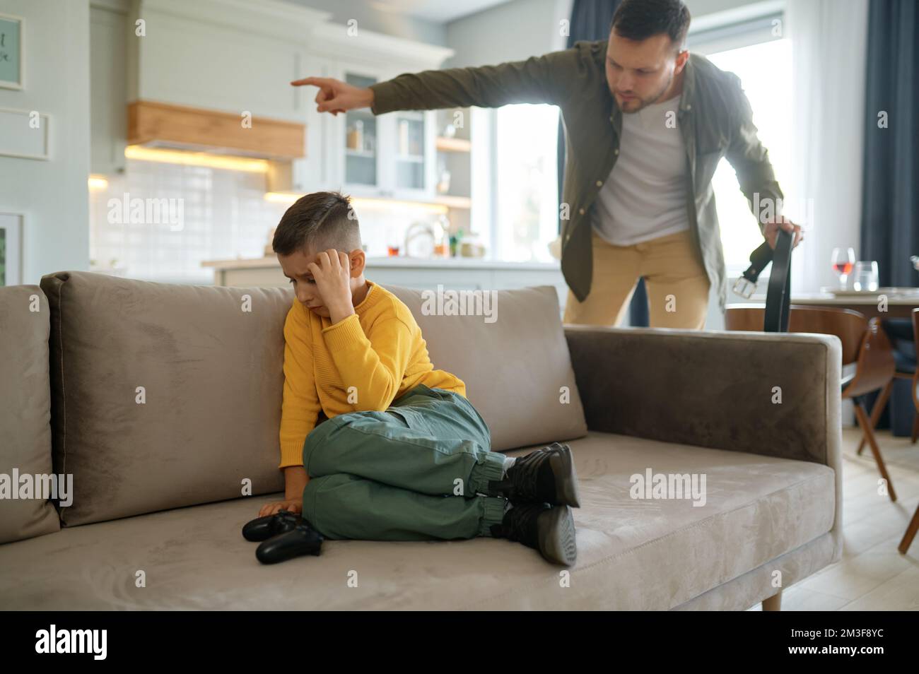 Père avec ceinture de cuir criant sur son jeu vidéo d'ordinateur Banque D'Images