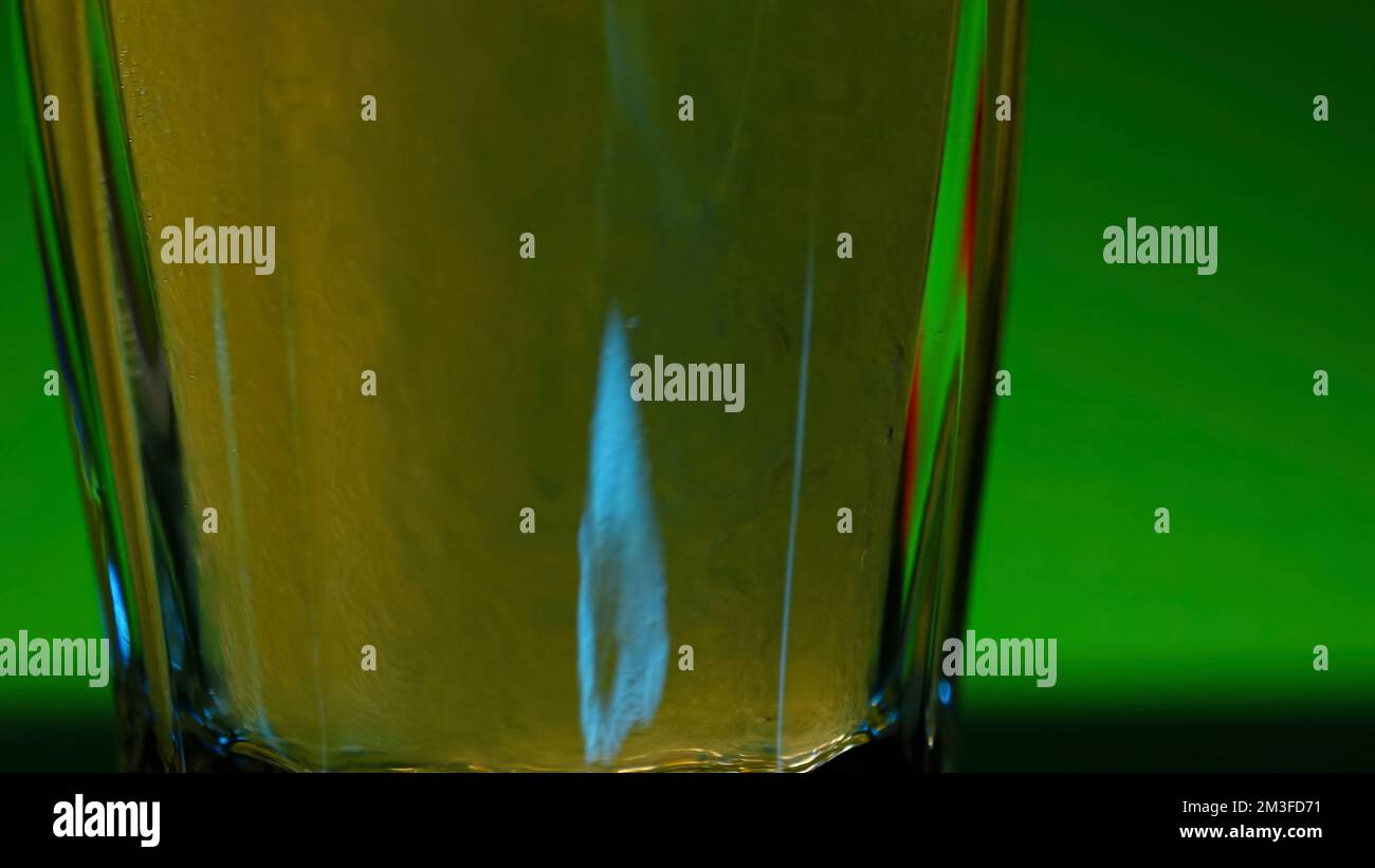 Fond vert . Clip de stock .Un fond lumineux sur lequel la limonade carbonée jaune est versée dans des verres. 4K images de haute qualité Banque D'Images