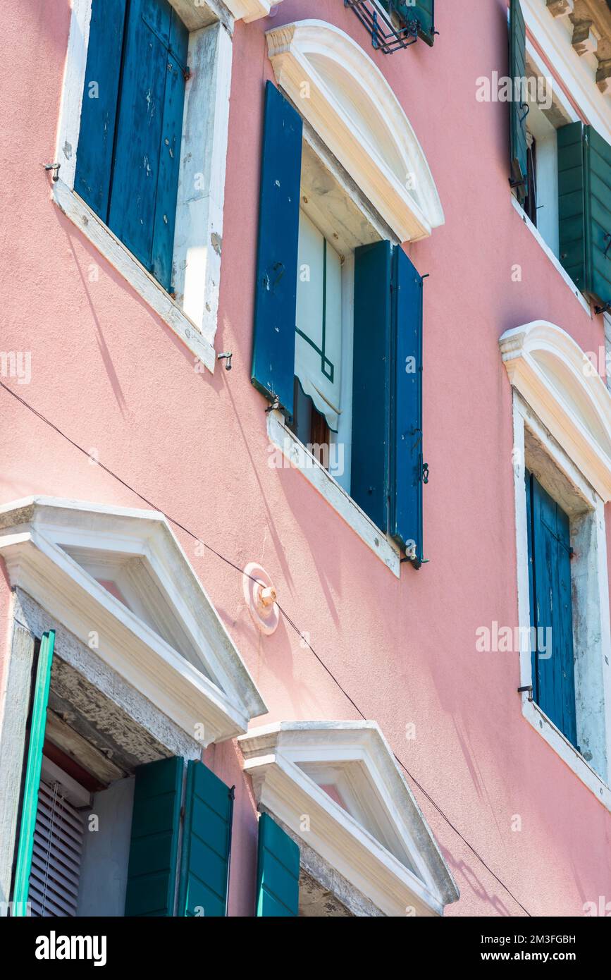 Maison rose, détail d'une élégante maison de ville rose avec des volets bleus dans le Corso del Popolo dans la pittoresque ville vénitienne de Chioggia, Vénétie, Italie Banque D'Images