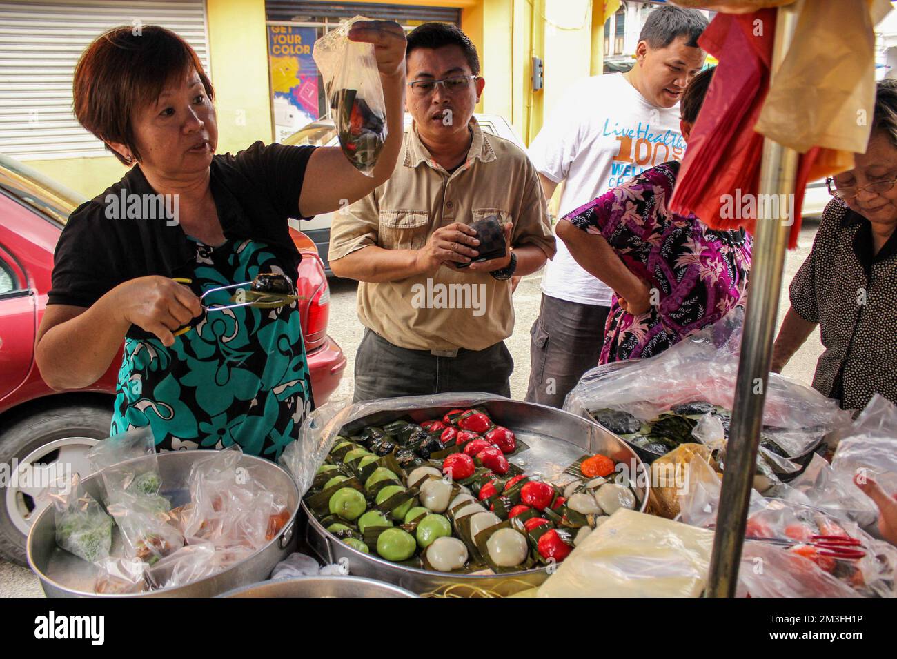 Ipoh, Perak, Malaisie - novembre 2012 : une femme qui vend des boulettes colorées dans sa rue dans un marché de la ville d'Ipoh. Banque D'Images