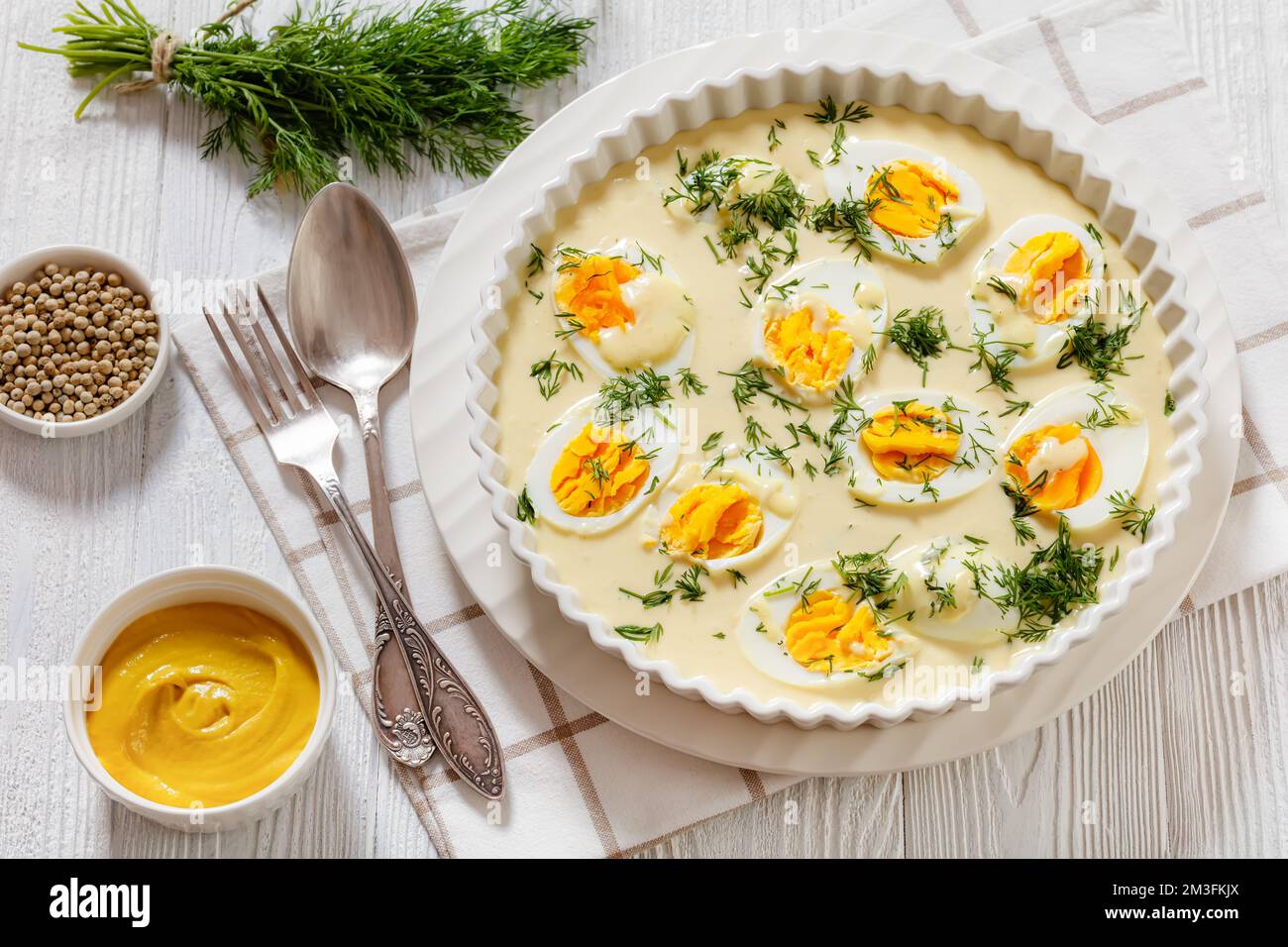 Senfeier, œufs durs, riche sauce moutarde crémeuse, plat blanc sur table en  bois blanc, cuisine allemande Photo Stock - Alamy