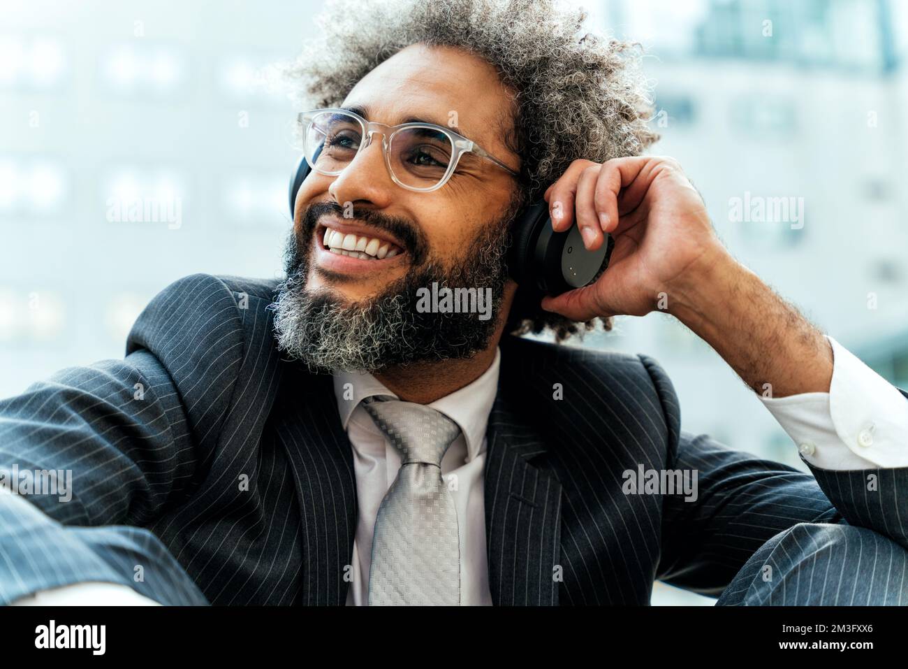 Jeune entrepreneur homme d'affaires à l'écoute de musique et de danse à l'extérieur du bureau. Concept de liberté et de réussite dans les affaires Banque D'Images