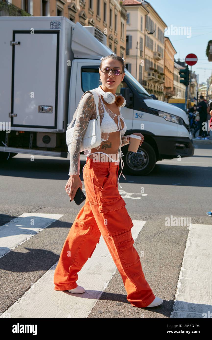 MILAN, ITALIE - 23 SEPTEMBRE 2022: Femme avec pantalon cargo orange et soutien-gorge blanc avant le spectacle de mode Sportmax, Milan Fashion week Street style Banque D'Images