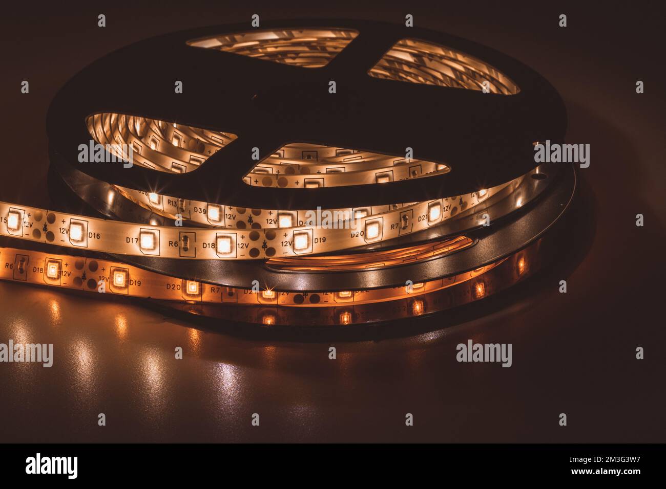 De la partie supérieure de la bobine avec un rouleau d'éclairage à LED luminescent placé sur la table dans la pièce sombre Banque D'Images