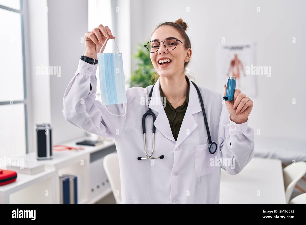 Jeune fille hispanique tenant un inhalateur d'asthme médical à la clinique  souriant et riant fort parce que drôle de blague folle Photo Stock - Alamy