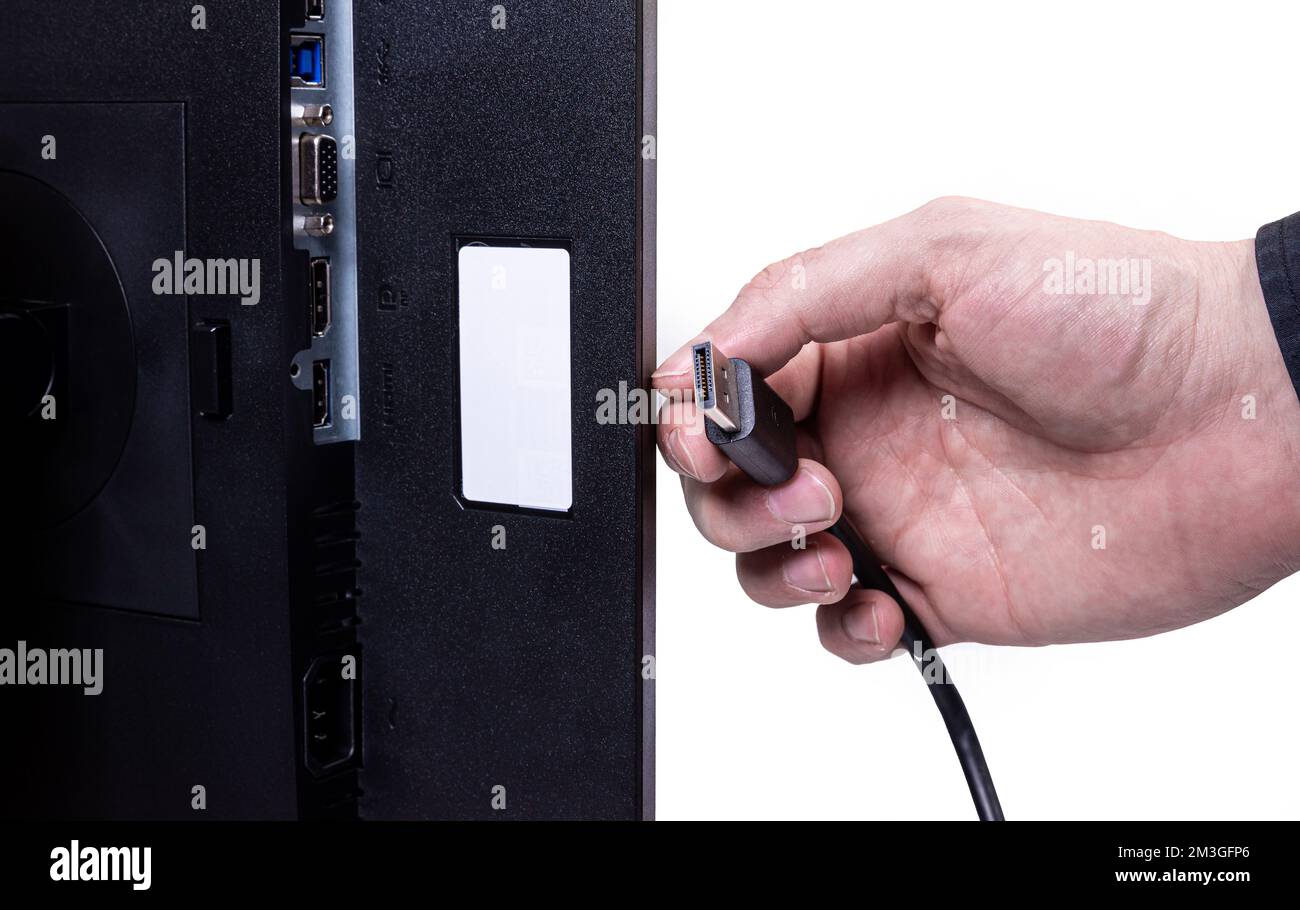 L'ingénieur INFORMATIQUE Man Hand insère le câble dans le moniteur. Homme à la main pour connecter le câble DVI du moniteur à l'ordinateur. VGA DVI DisplayPort et câble d'alimentation. cl Banque D'Images